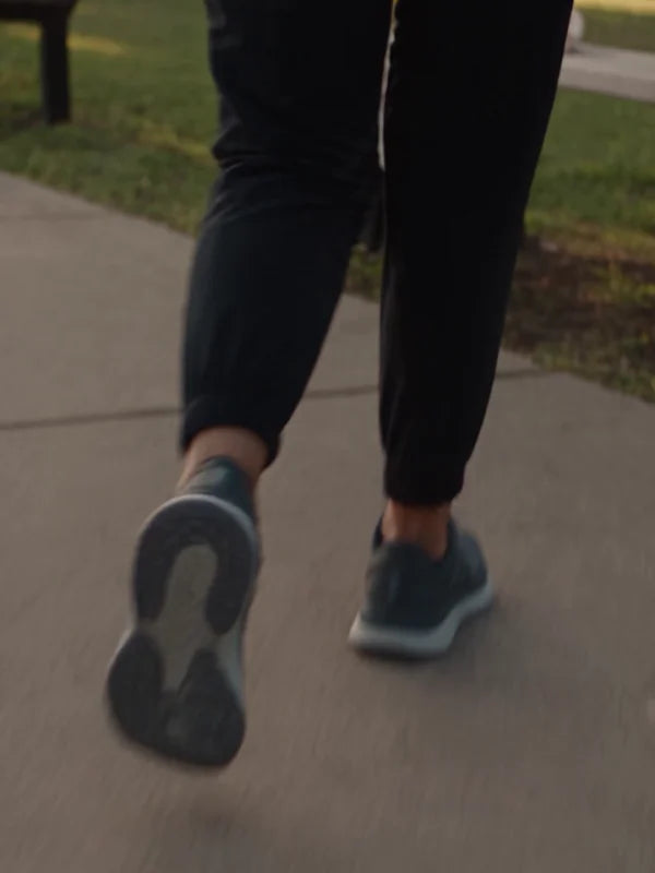Close-up of running shoes in motion on a park path